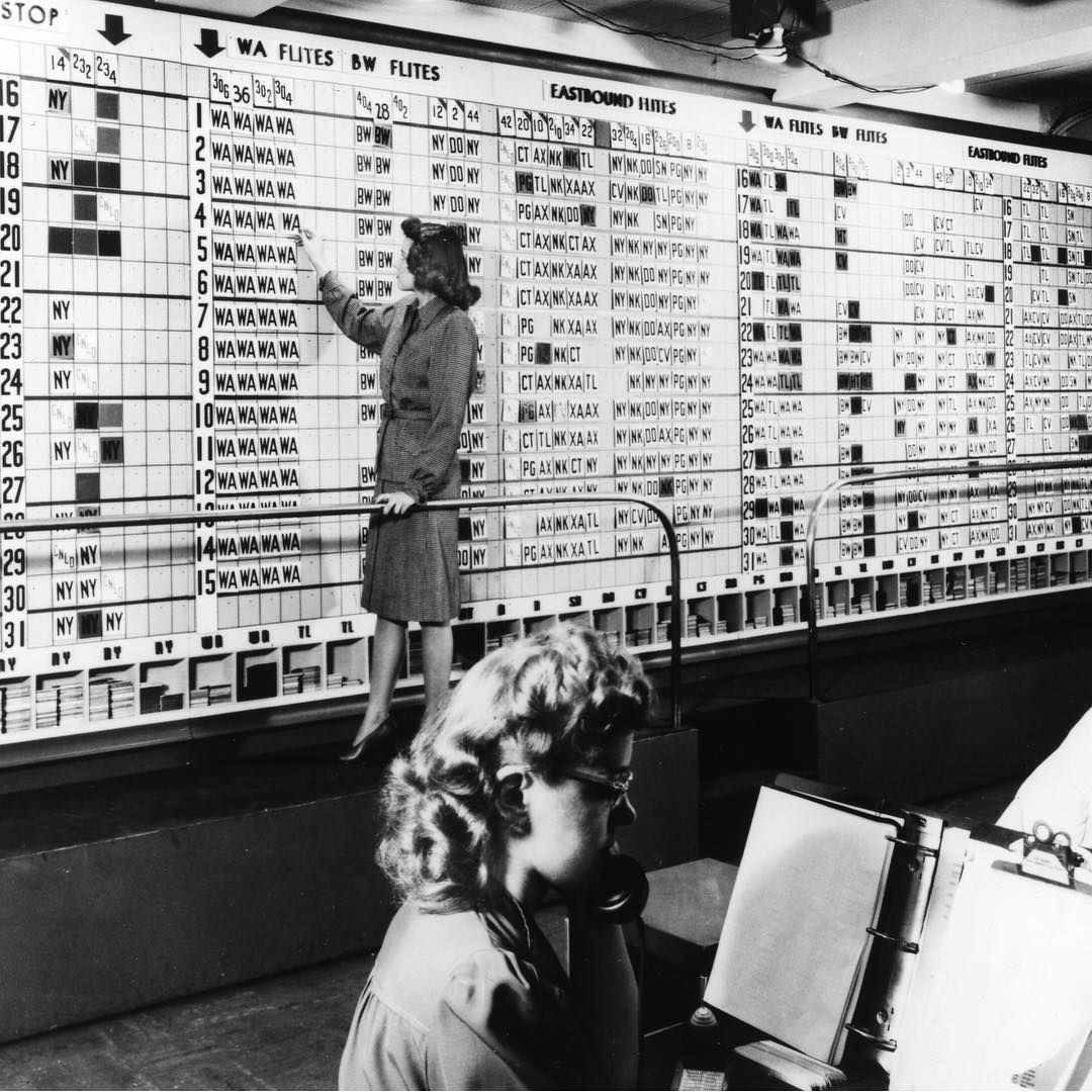 A woman standing in front of a huge analogue planning board