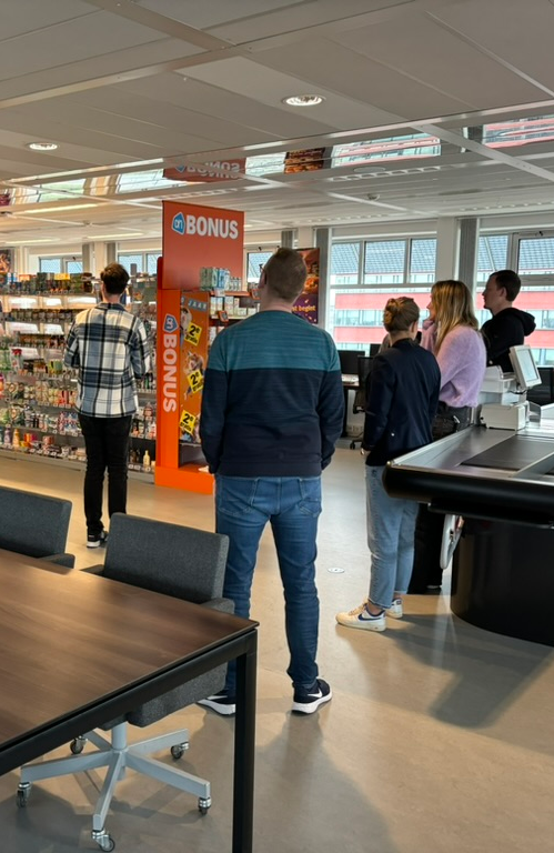 Group of people standing in a test grocery store during the dry run of an evaluation